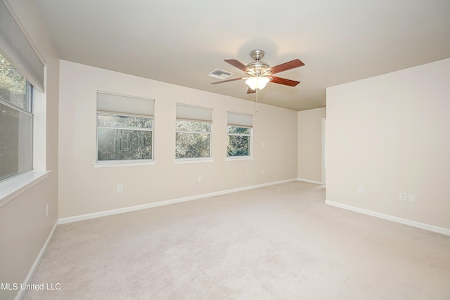 unfurnished room with light colored carpet, ceiling fan, and a healthy amount of sunlight