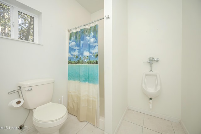 bathroom featuring a shower with shower curtain, tile patterned floors, and toilet