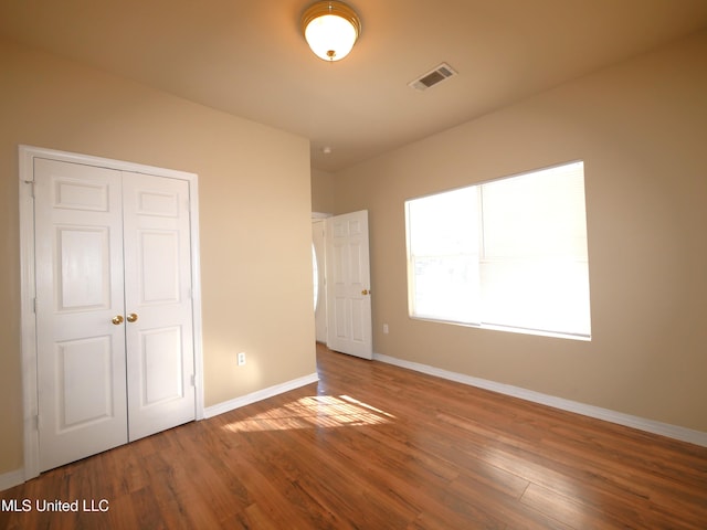 unfurnished bedroom featuring hardwood / wood-style floors and a closet