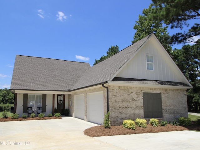 view of front of home with a garage, brick siding, a porch, and driveway