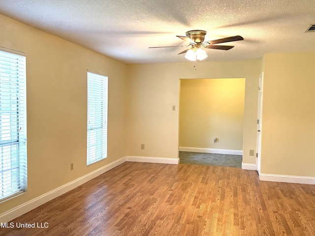 1606 Woodhaven St, Pascagoula, MS 39581 - spare room featuring wood finished floors, ceiling fan, plenty of natural light, a textured ceiling, and baseboards