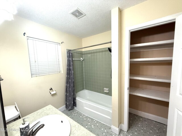1606 Woodhaven St, Pascagoula, MS 39581 - full bath featuring vanity, shower / bathtub combination with curtain, tile patterned flooring, a textured ceiling, and baseboards