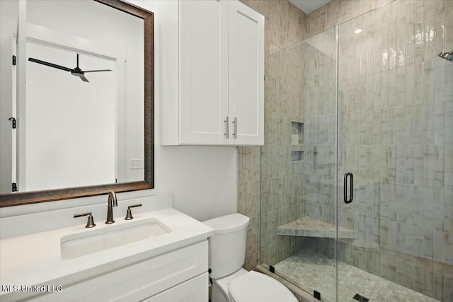 bathroom with a shower with door, vanity, and toilet