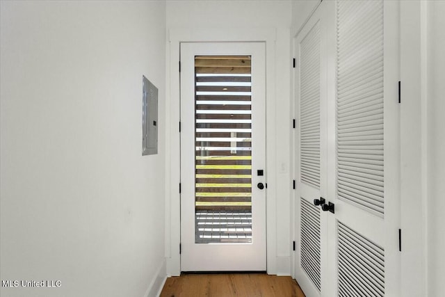 doorway with electric panel and light hardwood / wood-style flooring