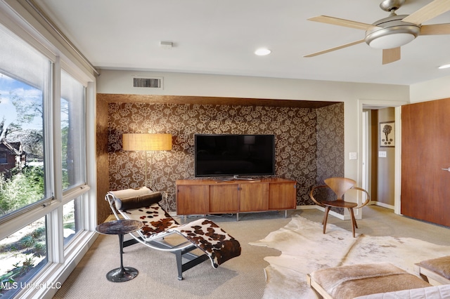 living room with light carpet, a healthy amount of sunlight, and ceiling fan