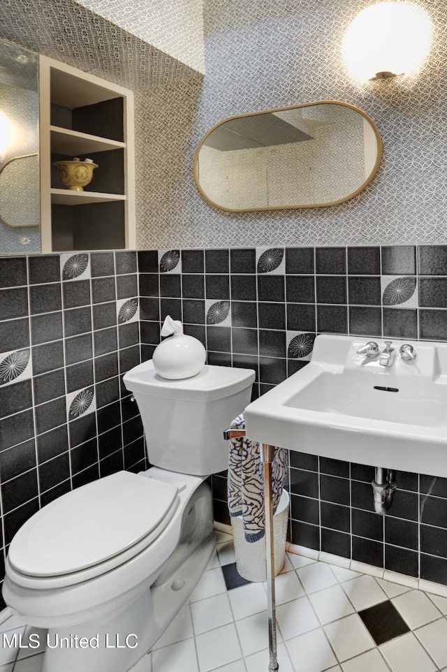 bathroom featuring toilet, tile walls, and tile patterned flooring