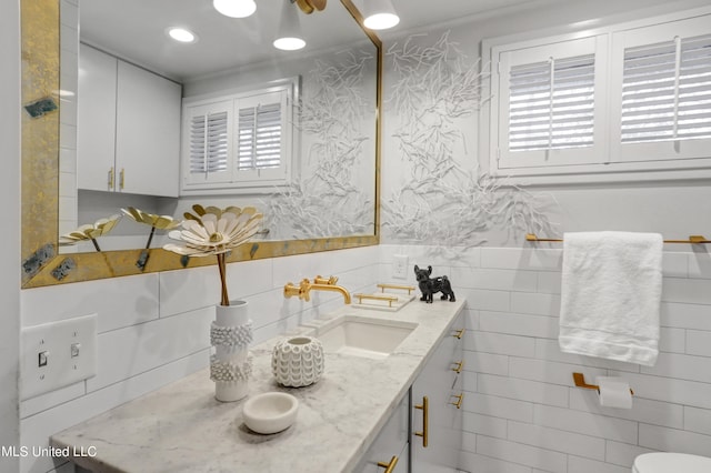 bathroom featuring vanity, toilet, crown molding, and tasteful backsplash