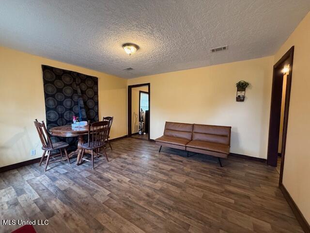 dining space with dark hardwood / wood-style flooring and a textured ceiling