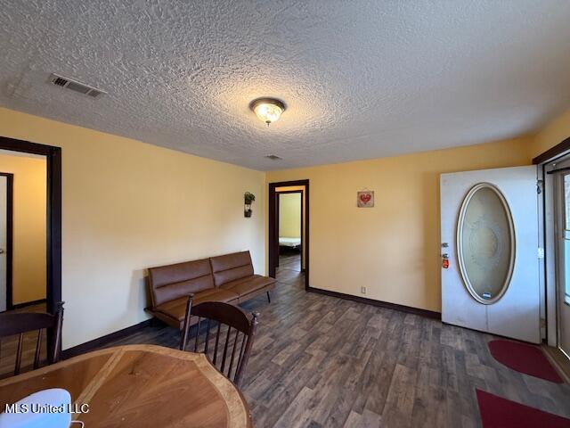 interior space featuring dark wood-type flooring and a textured ceiling