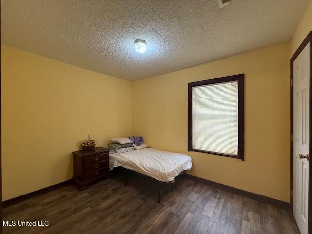 unfurnished bedroom featuring dark hardwood / wood-style floors and a textured ceiling