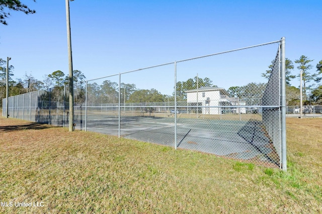 view of sport court with a lawn