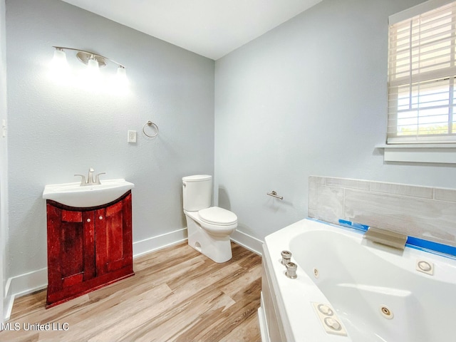 bathroom with vanity, a tub to relax in, wood-type flooring, and toilet