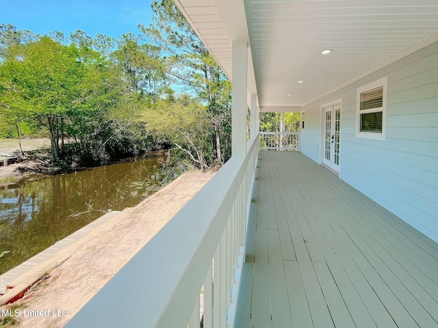 wooden terrace with french doors and a water view