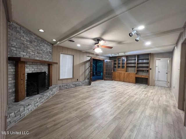 unfurnished living room with light hardwood / wood-style floors, ceiling fan, and a brick fireplace