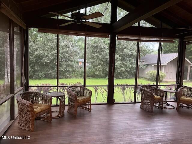 sunroom / solarium with lofted ceiling with beams and ceiling fan