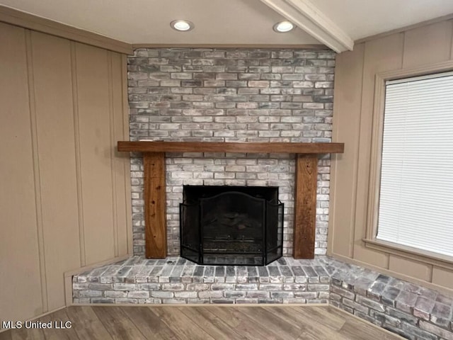 details featuring hardwood / wood-style floors, beam ceiling, and a fireplace