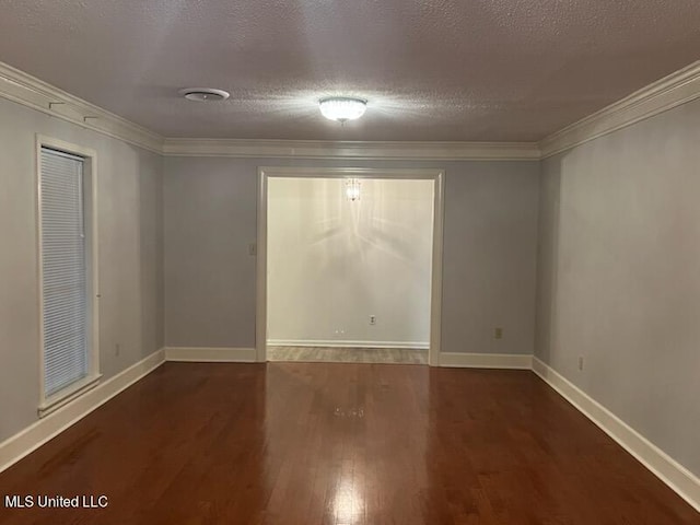 empty room featuring dark wood-type flooring, crown molding, and a textured ceiling