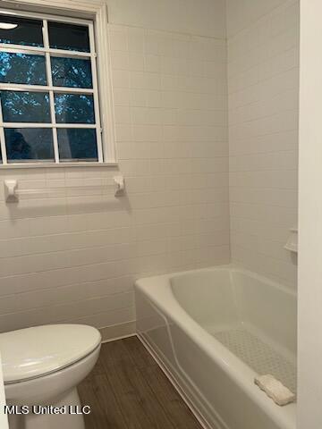 bathroom with toilet, hardwood / wood-style floors, and separate shower and tub