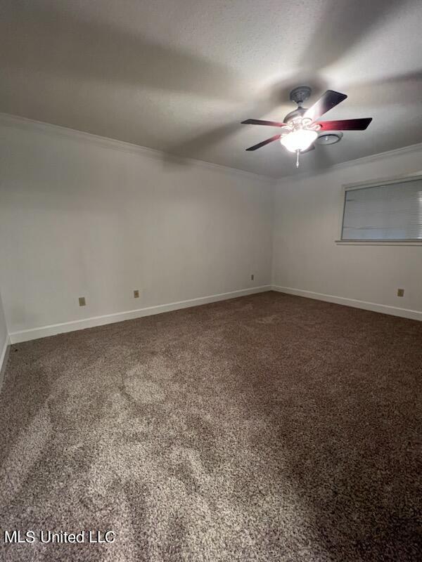 carpeted empty room featuring ceiling fan and crown molding