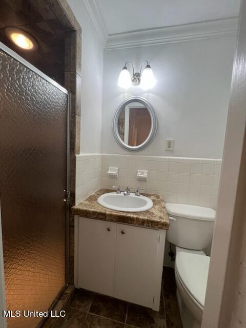 bathroom with toilet, a shower with shower door, vanity, crown molding, and tile patterned floors