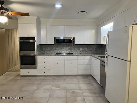 kitchen featuring crown molding, white cabinets, tasteful backsplash, appliances with stainless steel finishes, and ceiling fan