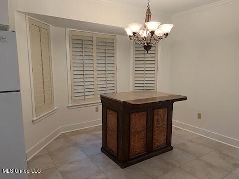 unfurnished dining area with crown molding, a notable chandelier, and light tile patterned floors