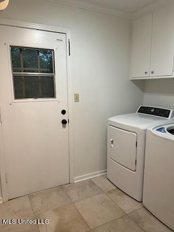 laundry area featuring cabinets, ornamental molding, and separate washer and dryer