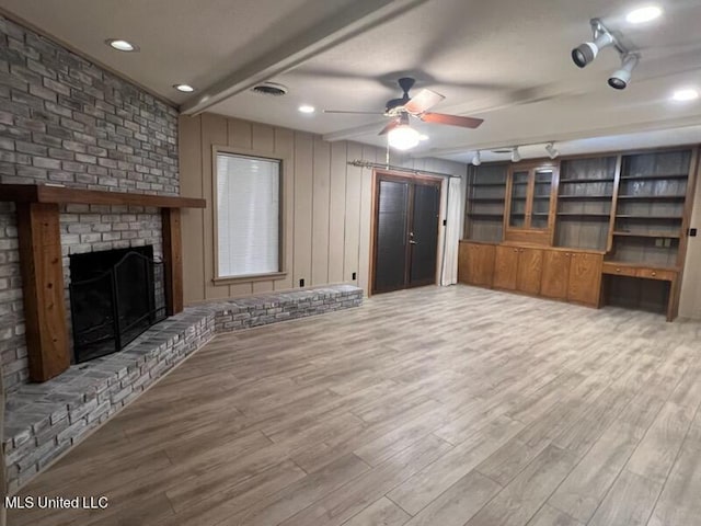 unfurnished living room with light hardwood / wood-style floors, a brick fireplace, and ceiling fan