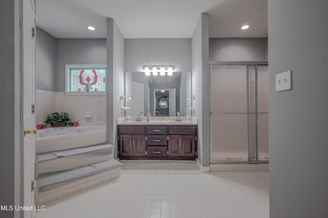 bathroom featuring vanity, tile patterned flooring, and tiled tub