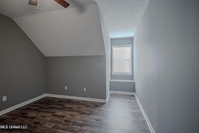 additional living space with ceiling fan, lofted ceiling, a textured ceiling, and dark hardwood / wood-style floors