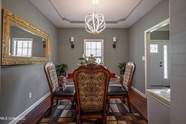 dining room featuring dark hardwood / wood-style flooring, a chandelier, and a textured ceiling