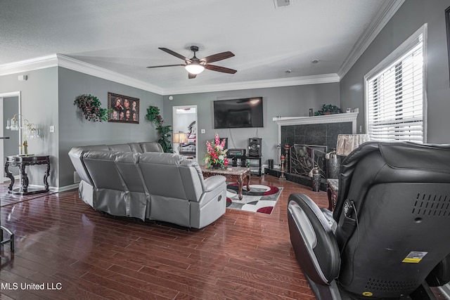 living room featuring dark hardwood / wood-style flooring, a textured ceiling, ceiling fan, crown molding, and a fireplace