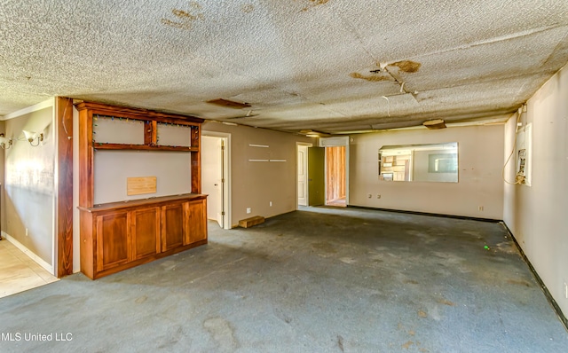 unfurnished room featuring a textured ceiling and baseboards