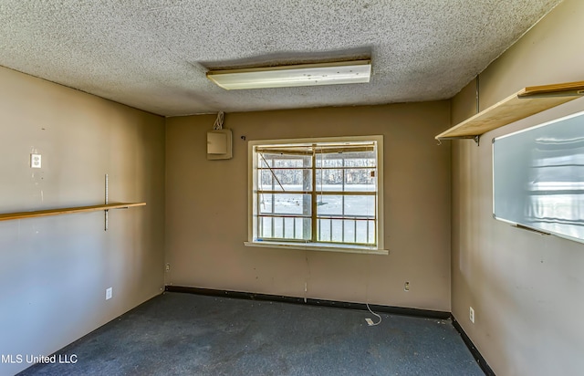 spare room with baseboards and a textured ceiling