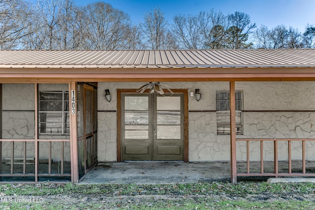 property entrance featuring stucco siding and metal roof