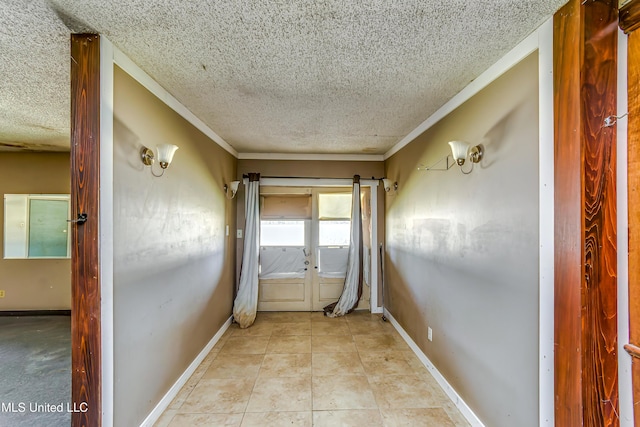 hall with light tile patterned floors, a textured ceiling, baseboards, and ornamental molding