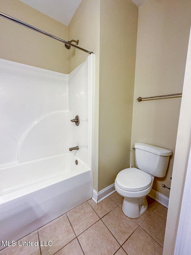 bathroom with toilet, tile patterned flooring, and bathing tub / shower combination