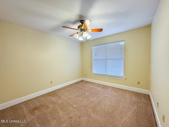 carpeted spare room featuring ceiling fan