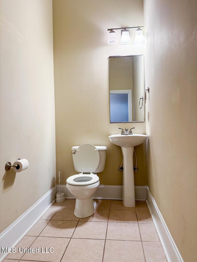 bathroom featuring toilet and tile patterned flooring