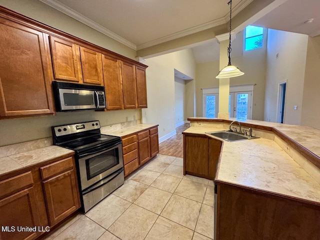 kitchen featuring pendant lighting, stainless steel appliances, sink, light tile patterned floors, and crown molding