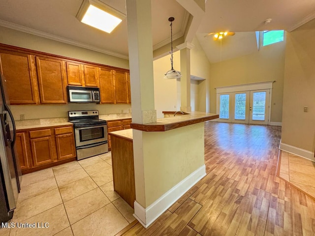 kitchen with stainless steel appliances, french doors, hanging light fixtures, high vaulted ceiling, and crown molding