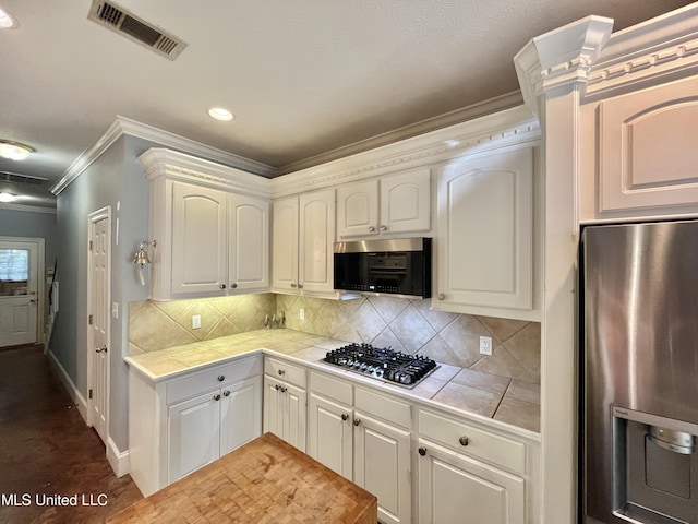 140 Whisper Lake Blvd, Madison, MS 39110 - kitchen featuring stainless steel appliances, tile countertops, crown molding, decorative backsplash, and baseboards