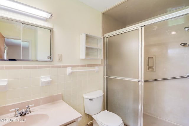 820 Lackland Dr, Biloxi, MS 39532 - full bathroom featuring a stall shower, vanity, toilet, tile walls, and a wainscoted wall