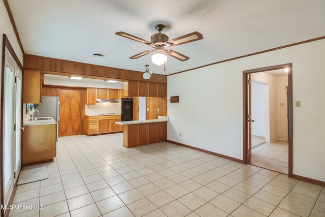 820 Lackland Dr, Biloxi, MS 39532 - kitchen with light countertops, a peninsula, a ceiling fan, brown cabinets, and wood walls