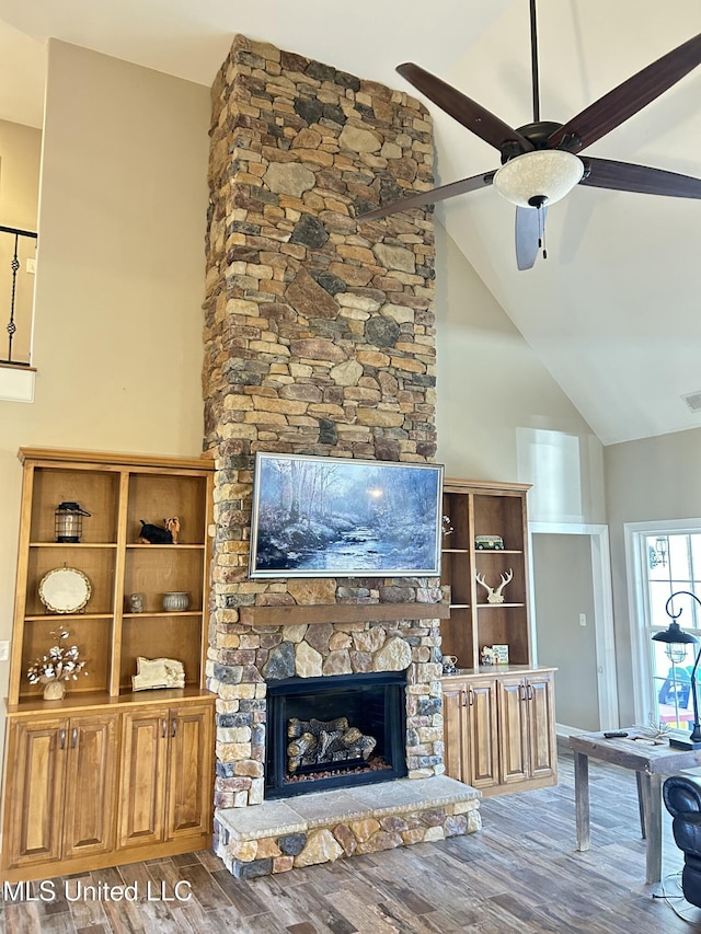 unfurnished living room featuring ceiling fan, a fireplace, high vaulted ceiling, and wood-type flooring