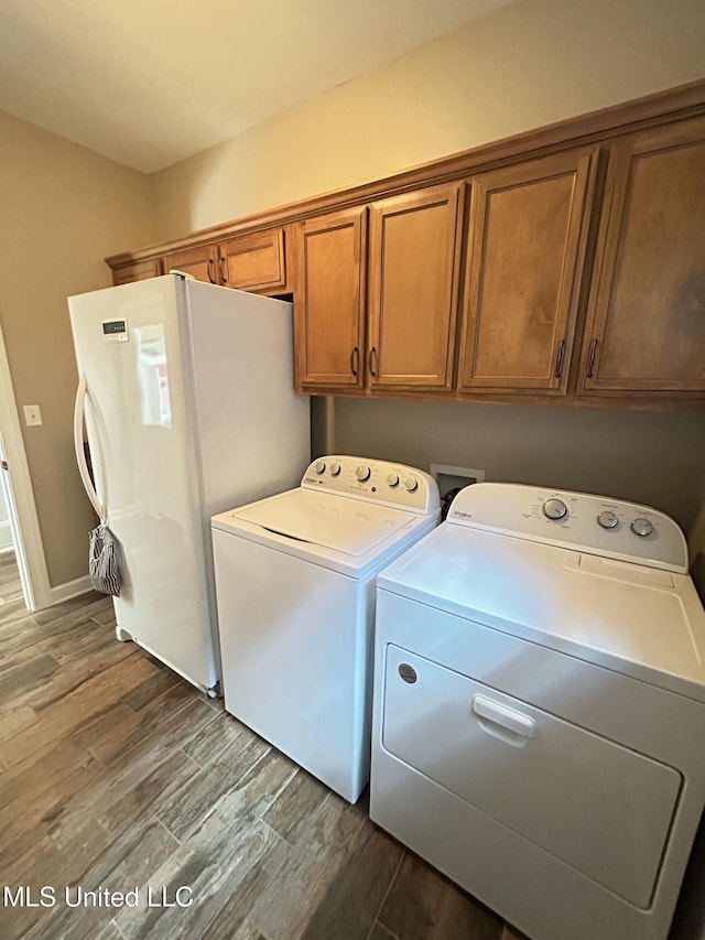 laundry room with cabinets, hardwood / wood-style flooring, and washer and dryer