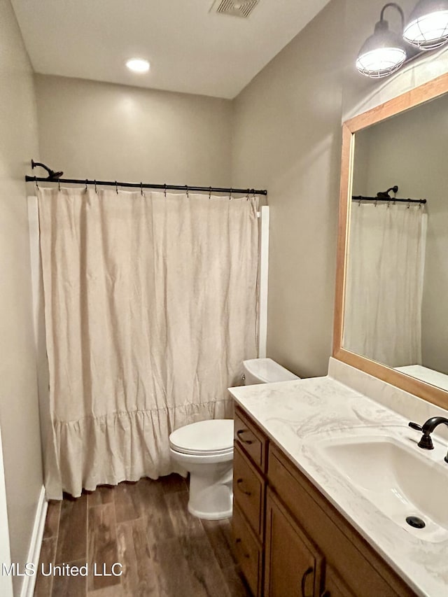 bathroom featuring vanity, hardwood / wood-style floors, and toilet