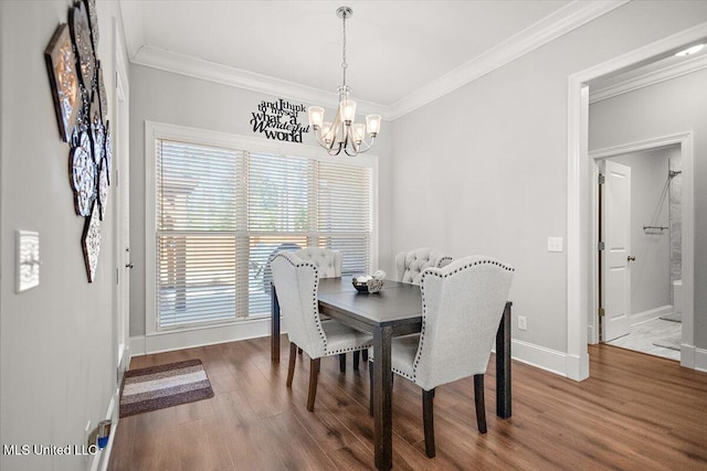 dining space featuring ornamental molding, wood-type flooring, and an inviting chandelier