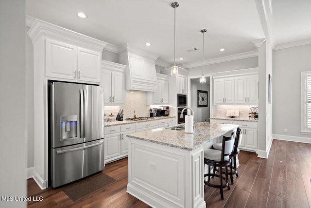 kitchen featuring white cabinetry, appliances with stainless steel finishes, and a center island with sink