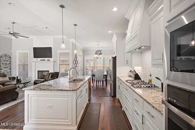 kitchen featuring white cabinetry, stainless steel appliances, and a kitchen island with sink